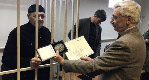 Oleg Orlov shows the Franco-German Prize "For Human Rights and Rule of Law" awarded to Oyub Titiev. Photo by Patimat Makhmudova for the Caucasian Knot