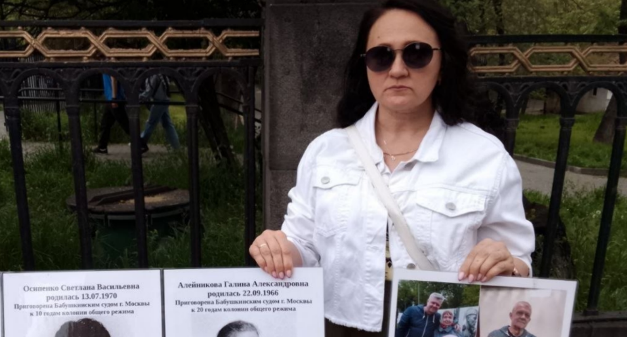 A picketer holds signs. Screenshot from RusNews photo from May 2, 2026, https://t.me/rusnews/84132. A picketer holds signs. Screenshot from RusNews photo from May 2, 2026, https://t.me/rusnews/84132.